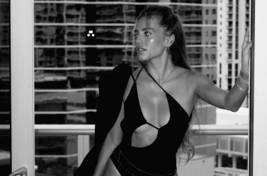 Gökdelen manzaralı panoramik pencere arka planında seksi bir kadın. Büyük panoramik pencerenin yanında şık giyinmiş güzel bir kadın.