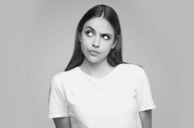 Düşünen düşünceli bir kadın düşünceli bir şekilde planlarını gri arka planda izole eder. Güzellik kraliçesi düşünüyor. Düşünceli bir kadının portresi. Düşünceli kız karar vermeyi düşünüyor.