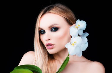 Güzellik bakımı. Kozmetik ürünleri. Orkide çiçekli kadın.