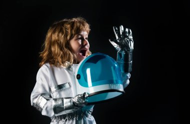 Uzay çocukları kozmonot konsepti. Mutluluktan kask takan küçük pozitif bir çocuğun portresi. Kopya alanı ile izole edilmiş arkaplan. Astronot kostümü giymiş bir çocuk astronot olma hayalleri kuruyor.