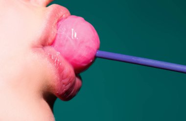 Pembe dudakları olan, lolipop tutan seksi bir kadın ağzı, güzellik kapanışı. Seksi kız lolipopu yaladı. Güzellik konsepti, yakın plan.