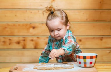 Mutfaktaki fırıncı çocuk. Ufaklık mutfakta yemek pişirmeye, unla oynamaya yardım ediyor.