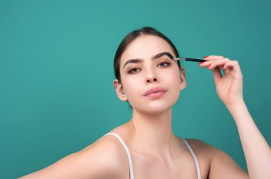 Maskaralı kaşlar. Doğal güzellik kaşları. Kaş boyama ve kaplama. Kaşlarını tarayan bir kadın. Makyaj ve kozmetik konsepti. Kaş şekli modelleme