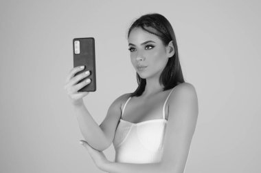 Stüdyonun arka planında izole edilmiş telefon aygıtı uygulaması kullanan bir kız. Akıllı telefon tutan, cep telefonuyla konuşan bir kadın. Telefon kullanan bir kız, stüdyo resmi. Kadın telefonla konuşuyor.