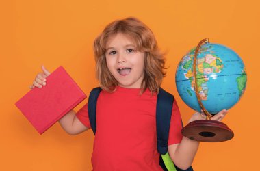 Okul çocukları. Dünya küresi ve kitabı olan bir okul öğrencisi. Çalışan inek öğrencinin stüdyo portresi