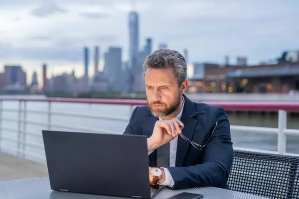 stock image Businessman using a laptop outdoors. Online Business. Businessman Using Laptop Outdoor. Business Man with Laptop on Big City Street. Digital data management. Businessman freelancing in NY