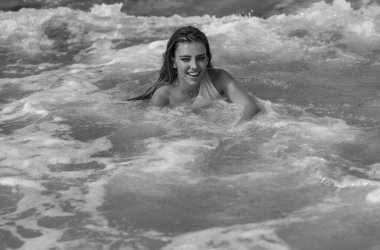 Plaj tatilinde bronzlaşmış seksi ince bikini modeli. Denizde bikinili bir kız. Bikinili seksi bir kadın vücudu. Tropik plajda yaz tatili. Yaz iç çamaşırı bikini.