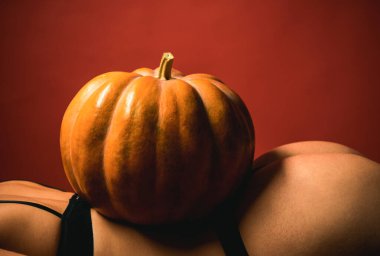 Büyük göt ve kabak. Reklam kavramı. Seksi balkabağı kalça. Cadılar Bayramı partisi kızlar. Seksi Halloween sanat tasarımı. Kalça popo ve kabak yakın çekim