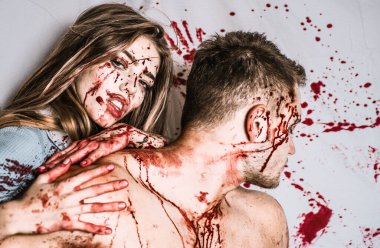 Cadılar Bayramı Zombi birkaç kaslı adam ve yaralar ve kırmızı kanlı kanlı genç kadın. Kanlı bir çift, bir vampir kız kaslı bir adam boynundan ısırıyor