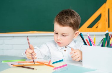 Kalem kullanarak deftere yazı yazmasına şaşırdım. Öğrenci çocuk evde çalışıyor ve ev ödevi yapıyor.