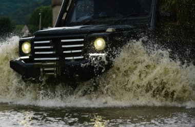 Off-road yarışında çamur ve su sıçraması. Çamurlu bir arazide izler. Büyük 4x4 arabalı seyahat konsepti. Çamur, ıslak çamur veya kilden oluşan bir alanda off-road yapmaktır.