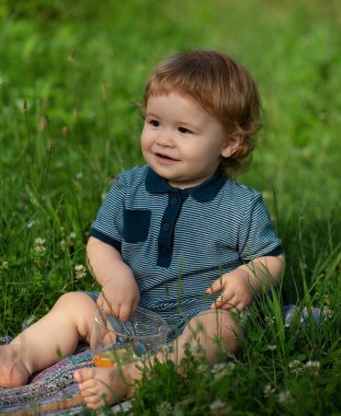 Küçük çocuk parkta oynuyor. Otlakta mutlu bir bebeğin portresi