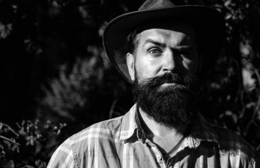 Kovboy şapkalı ciddi bir adamın yakın portresi.