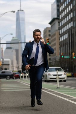 New York 'ta telefonu olan bir iş adamı. İş konuşmaları. İş adamı caddede koşup telefonla konuşuyor. Takım elbiseli adam geç kaldı. İş görüşmesi. İşletme adamı. Hızlı iş. Koş ve geç iş adamı