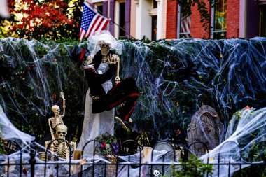 Cadılar Bayramı süslemeleri. Amerikan evi için Cadılar Bayramı balkabağı ve iskeleti. Bir Amerikan evinin ön bahçesinde dekore edilmiş korkunç bir şey. Şeker mi şaka mı? Amerika 'da Cadılar Bayramı. Amerika 'da Cadılar Bayramı