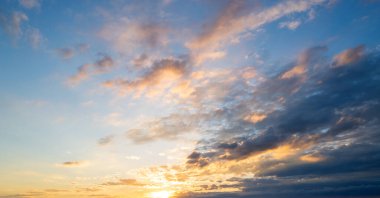 Gün batımı ya da gün doğumu. Dramatik görkemli gün batımı. Gökyüzü bulutlu ve gökyüzü aydınlık arka planda. Farklı şekillerde bulutlarla gün doğumu. Sakin gün batımı gökyüzü ve bulutlar arasında güneş