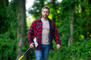 Ekose gömlekli oduncu doğa kökenli. Acımasız oduncu. Odun kesiyorum. Keskin bıçak. Vahşilik ve erkeklik. Sakallı oduncu. Oduncu tarzı. Baltalı adam. Sakallı adam, balta tut.