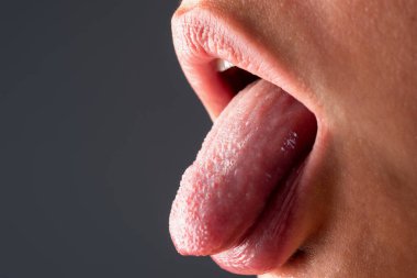 Seksi dil yalama, yakından. Kadın yüzü, ağzı, dudakları ve dilinin kesilmiş görüntüsü. Doğal dudaklar. Mükemmel doğal dudak. Makro dil. Ağız dili ikonu. Güzel kadın ağzı. Yakın plan.
