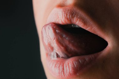 Seksi dil yalama, yakından. Kadın yüzü, ağzı, dudakları ve dilinin kesilmiş görüntüsü. Doğal dudaklar. Mükemmel doğal dudak. Makro dil. Ağız dili ikonu. Güzel kadın ağzı. Yakın plan.