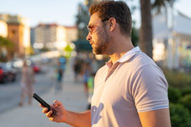 Şehirdeki adam Tampa 'da telefonla konuşuyor. Amerikan şehrinde sıradan giyinmiş, telefonda konuşan çekici bir adamın portresi. Dışarıda telefon kullanan yakışıklı bir genç. İş telefonu görüşmesi