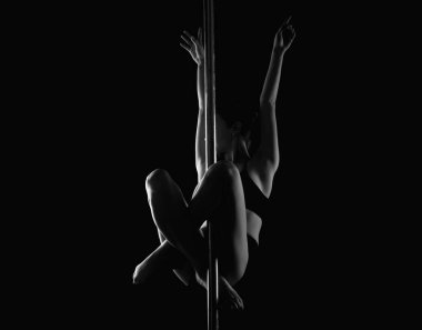 Gri stüdyo arka planında poz veren güzel bir kadın dansçı. Esnek seksi kadın. Şehvetli kız zayıf vücudunu esnetiyor. Zarif bir bayan jimnastikçi mükemmel biçimli vücuduyla poz veriyor. Fıçıları geriyorum