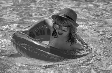 Çocuk yüzüyor ve havuzda oynuyor. Çocuk yüzme havuzunda oynuyor. Yaz tatili kavramı. Yaz çocukları portresi