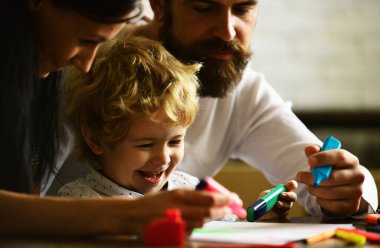 Mutlu bir anne, baba ve çocuk. Hafta sonları çocukları çizen mutlu bir aile. Çocuk resim öğreniyor, ressam resmi yapıyor, resim çiziyor. Çocuk günü