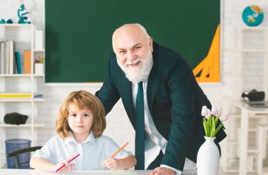 Profesör ya da öğretmen küçük öğrenciyi eğitiyor. Öğretmen yetenekli bir lider. Eğitici konuşma. Öğrencilerle ya da öğrencilerle konuşmak. Öğretmen konsepti. Pedagog ve öğrenci eğleniyor.