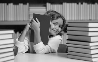 Akıllı öğrenci. Bilgi ve eğitim okulu konsepti. Öğrenci kütüphanede kitap okuyor. Çocuklar okumayı öğrenir. Kitapçıda kitap okuyan bir çocuk