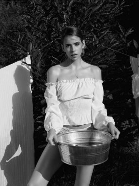 Yaz yeşilliklerinde poz veren seksi bir kadın. Köydeki genç ve seksi bayan. Açık hava eğlence aktivitesi. Kırsal ve yaşam tarzı konsepti. Kırsal tarzda. Doğa kadını.