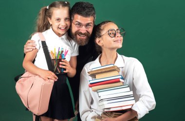 Stüdyoda öğretmeni olan ilkokul öğrencisi, izole edilmiş. Gülümseyen erkek öğretmen ve genç okul öğrencileri tahtada