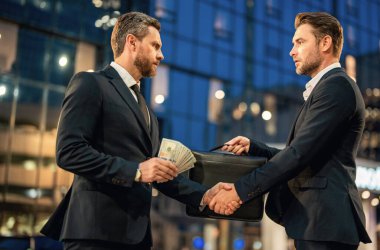 İş adamları takımlarının başarısına adanmıştır. İş adamları para veriyor. Gece şehrinde kolaj için para teklif eden bir iş adamı. İş için para teklif ediyor.