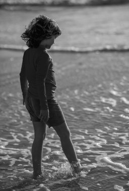 Happy child playing in the sea. Kid having fun outdoors. Summer vacation and healthy lifestyle concept. Cute kids having fun on beach in summer. Happy child playing in the sea. Summer vacation