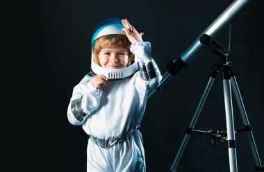 Çocuk astronot kaskı ve uzay kostümü giymiş. Uzay giysili küçük çocuk. Yaratıcı fikirler ve yenilik teknolojisi konsepti. Astronot kasklı komik çocuk portresi