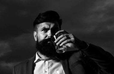 Lüks, zengin, sakallı adam pahalı içecekler içer. Sakallı bir adam cam konyak tutar, konyak içer. Hippi adam içkinin tadını aldı. Viski yudumluyor. Gece hayatı.