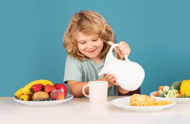 Çocuk süt içiyor. Kahvaltılık süt içen bir çocuk. Sağlıklı çocuk sütten süt döker.