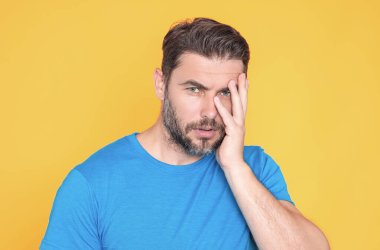 Düşünen düşünceli bir adam düşünceli bir şekilde kenara bakar ve planlarını sarı arka planda izole eder. Yakışıklı düşünen bir adam düşünüyor. Düşünen bir adamın portresi. Düşünceli adam karar vermeyi düşünüyor.