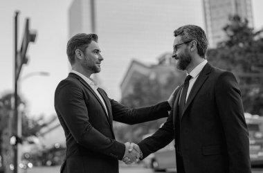 Başarılı bir takım çalışması. İş adamları el sıkışıyor. İki iş adamı arasında tokalaşma. Şehir caddesinde el sıkışan iki işadamı. Takım elbiseli işadamları dışarıda el sıkışıyor. İş ekibi