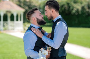 Düğünde eşcinsel damat. Düğünde çiçeklerle el ele tutuşan mutlu eşcinsel çift. Romantik ve şehvetli eşcinsel çift. Eşcinsel damatlar düğün gününde birlikte