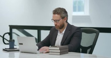 Modern ofis. İşletme takımında başarılı bir beyaz iş adamı dizüstü bilgisayar kullanıyor, uzaktan kumandayla çalışıyor, e-ticaret yapıyor. Finans denetçisi. Yönetim kurulu başkanının iş fikri var. İş dünyası