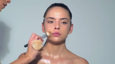 Profesyonel makyöz güzel genç bir kadınla çalışıyor. Seksi mankeni telafi et. Makyaj sanatçısı güzel makyaj yapıyor. Profesyonel makyöz, cazibe modeli makyajı yapıyor.