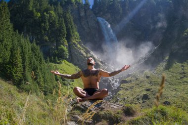 Seksi fit adam meditasyonu. Spor mankeni doğada rahatlar. Meditasyon, ruhsal sağlık. Sakin bir meditasyon adamı farkındalığı eğitiyor. Rahatlayın ve doğada meditasyon yapın. Sakin ol ve doğada rahatla.