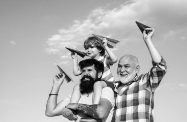 Büyükbaba, baba ve oğul sarılıyor ve birlikte eğleniyorlar.