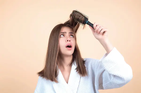 stock image Sad girl with damaged hair. Haircare problem. Woman with hair loss problem. Portrait of young woman with a damaged bad hair. Girl with a hairbrush loosing hair. Hairs are tangled, frizzy and messy