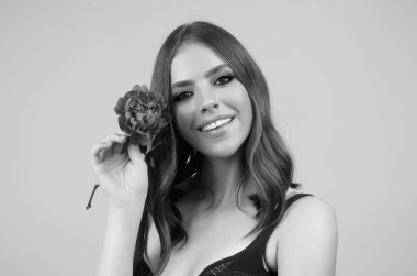 Sevgililer Günü. Yüzünde kırmızı şakayık olan güzel kız. Güzel şehvetli kadın şakayık çiçeğini tut, bej arka planda stüdyo portresi