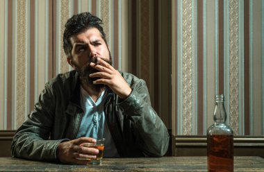 Adam brendi ya da viski içer. Sakallı adam takım elbise giyip viski ya da konyak içiyor. Sommelier alkollü içeceğin tadını alıyor. İçki ve parti konsepti. Degukasyon ve tatma
