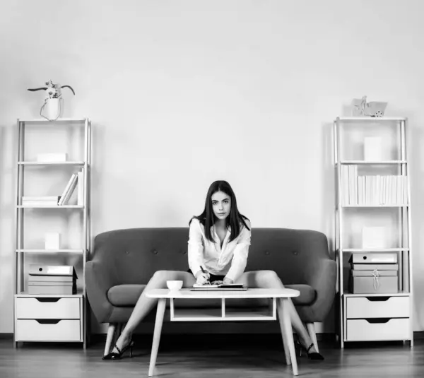 stock image Sexy business woman. Seductive business woman at desk in office interior. Long legs of accountant girl