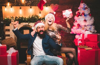 Christmas time for happy friends. Drunk Girls celebrate New Year. Woman and handsome man with Santa dress clipart