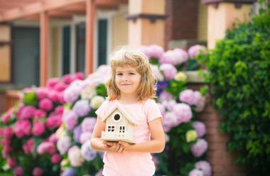 Oyuncak ev, aile evi. Gayrimenkul konutları, evde bakım, aile gündüz bakımı konsepti. Mutlu çocuk yeni bir ev hayal ediyor.