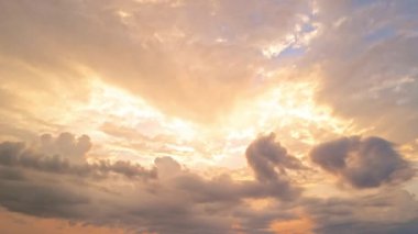 Güneşli gün batımı ve mavi bulutlar ve güneş ışınlı turuncu dramatik gökyüzü. Gece Gökyüzü zaman çizelgesi. Gün batımında hareket eden bulutlar. Akşam bulutları. Alacakaranlık gökyüzü zaman aşımına uğradı. Dramatik gökyüzü